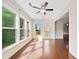Sunlit sunroom with hardwood floors, large windows offering outdoor views, and a ceiling fan at 522 Spring View Dr, Woodstock, GA 30188