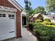 Home featuring a brick facade and white garage door, surrounded by lush landscaping at 3587 Plum Creek Nw Trl, Kennesaw, GA 30152
