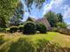 View of the side yard with lush green grass and landscaped shrubbery at 3587 Plum Creek Nw Trl, Kennesaw, GA 30152