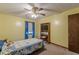 The yellow bedroom has a wood door, ceiling fan, tv with a bookshelf, and a window at 1667 Quail Run, Conyers, GA 30094
