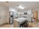 Well-lit kitchen with stainless appliances, white cabinets, and large center island with barstool seating at 1667 Quail Run, Conyers, GA 30094