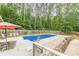 Sparkling in-ground pool surrounded by ample patio space, landscaping, seating, and a wooden privacy fence at 1667 Quail Run, Conyers, GA 30094