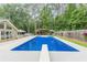 Beautiful in-ground pool with diving board, surrounded by lush greenery, landscaping, and large patio at 1667 Quail Run, Conyers, GA 30094