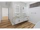 This bathroom has hardwood floors, double sinks, a floating vanity, and hexagon tile accents at 1711 Summit Glen Ln, Atlanta, GA 30329
