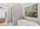 Bright bathroom featuring a large soaking tub with views of a wooded area at 1711 Summit Glen Ln, Atlanta, GA 30329