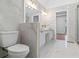 Bright bathroom featuring marble tile, dual sinks, and modern gold fixtures at 1711 Summit Glen Ln, Atlanta, GA 30329