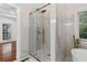 Modern bathroom with glass shower, marble countertops, and a window with natural light at 1711 Summit Glen Ln, Atlanta, GA 30329