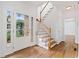 Bright foyer with hardwood floors, a staircase with white railings, and a front door with glass panels at 1711 Summit Glen Ln, Atlanta, GA 30329