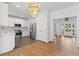 Spacious open concept with hardwood floors, a modern kitchen, and a dining area with an elegant chandelier at 1711 Summit Glen Ln, Atlanta, GA 30329