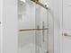 A shower is enclosed by a glass door with gold hardware and subway tile at 1711 Summit Glen Ln, Atlanta, GA 30329