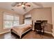 Comfortable bedroom features a ceiling fan, large window, and an adjacent desk with dual monitors at 2515 Gadsen Walk, Duluth, GA 30097