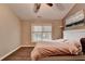 Bright bedroom featuring wood flooring, a ceiling fan, and a large window for natural light at 2515 Gadsen Walk, Duluth, GA 30097