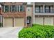 Traditional townhome featuring a brick facade, two-car garage, and manicured shrubbery at 2515 Gadsen Walk, Duluth, GA 30097