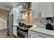 Well-lit kitchen featuring stainless steel appliances, white cabinets, and hardwood floors at 2515 Gadsen Walk, Duluth, GA 30097