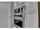 Modern stainless steel appliances including oven and microwave built into the white cabinets at 2515 Gadsen Walk, Duluth, GA 30097