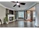 Large living room with dark floors, ceiling fan, and fireplace feature with large window at 2515 Gadsen Walk, Duluth, GA 30097