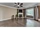 Bright living room with dark hardwood floors, fireplace feature, ceiling fan, and large window at 2515 Gadsen Walk, Duluth, GA 30097