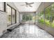Enclosed sunroom with tile flooring and multiple windows providing scenic views of the surrounding greenery at 3321 Georgian Woods Cir, Decatur, GA 30034