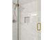 Elegant shower with white marble tiling, built-in niche, and glass door at 4254 River Green Dr # 613, Atlanta, GA 30327