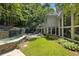 Lush backyard with mature trees, a patio, and a stone waterfall feature and hot tub at 625 Wynfield Ct, Roswell, GA 30076