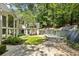 Picturesque backyard with a stone waterfall, lush greenery, and outdoor seating areas at 625 Wynfield Ct, Roswell, GA 30076