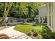 Beautifully landscaped backyard with grass, trees, and a soothing stone waterfall feature at 625 Wynfield Ct, Roswell, GA 30076
