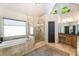 Bathroom featuring a soaking tub, glass-enclosed shower, double sink vanity, and large window at 625 Wynfield Ct, Roswell, GA 30076