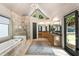 Bright bathroom featuring a soaking tub, glass-enclosed shower, double sink vanity, and vaulted ceiling at 625 Wynfield Ct, Roswell, GA 30076