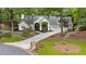 Charming home with a circular driveway and a well-manicured front lawn surrounded by mature trees at 625 Wynfield Ct, Roswell, GA 30076
