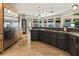 Modern kitchen with dark cabinetry, stone countertops, stainless steel appliances, and light wood floors at 625 Wynfield Ct, Roswell, GA 30076