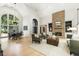 Open-concept living space with a stone fireplace, hardwood flooring, and modern furniture at 625 Wynfield Ct, Roswell, GA 30076