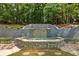 Stone waterfall with lush landscaping creating a relaxing backyard oasis at 625 Wynfield Ct, Roswell, GA 30076
