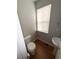 Cozy half bathroom featuring wood floors, a pedestal sink, and a window for natural light at 6817 Blackstone Pl # 16, Mableton, GA 30126