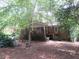 Backyard view of brick home with covered porch and mature trees for privacy at 2448 Sherbrooke Ne Ct, Atlanta, GA 30345