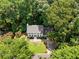 Aerial view of the home nestled among lush green trees with a well-maintained lawn at 5236 Forest Brook Pkwy, Marietta, GA 30068