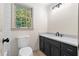 Updated bathroom featuring a black vanity with a sleek countertop and a stylish light fixture at 5236 Forest Brook Pkwy, Marietta, GA 30068