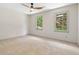 Bright, carpeted bedroom with two windows providing a beautiful outdoor view and a modern ceiling fan at 5236 Forest Brook Pkwy, Marietta, GA 30068