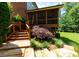 Backyard with a stone patio, wooden stairs, and lush landscaping at 141 Olde Heritage Way, Woodstock, GA 30188