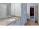 Bright bathroom featuring granite counters, wood look tile flooring, and a large vanity mirror at 141 Olde Heritage Way, Woodstock, GA 30188