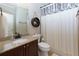 Cozy bathroom featuring granite countertop, decorative shelf, and shower with patterned curtain at 141 Olde Heritage Way, Woodstock, GA 30188