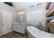 Elegant bathroom featuring a modern tub, window, and floating shelves for storage at 141 Olde Heritage Way, Woodstock, GA 30188