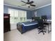 Cozy bedroom with a blue accent wall, ceiling fan, and a desk for a quiet study space at 141 Olde Heritage Way, Woodstock, GA 30188