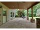 Spacious covered patio with stone columns, ceiling fan, and backyard views at 141 Olde Heritage Way, Woodstock, GA 30188