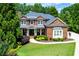 Beautiful brick home featuring mature landscaping and a welcoming front porch at 141 Olde Heritage Way, Woodstock, GA 30188