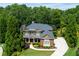 Beautiful exterior view of a brick home with a manicured lawn and lush landscaping at 141 Olde Heritage Way, Woodstock, GA 30188
