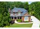 Charming two-story brick home with a beautifully landscaped front yard and inviting covered porch at 141 Olde Heritage Way, Woodstock, GA 30188