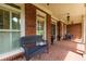 Covered front porch featuring classic brick, ceiling fans, and comfortable seating at 141 Olde Heritage Way, Woodstock, GA 30188