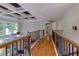 Upstairs hallway featuring hardwood floors, coffered ceiling, and natural light from large windows at 141 Olde Heritage Way, Woodstock, GA 30188