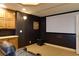 Home theater with a large screen, dark walls, carpeted floor, wooden cabinets and seating at 141 Olde Heritage Way, Woodstock, GA 30188