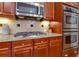 Close-up of the kitchen featuring stainless steel appliances, granite countertops and custom cabinets at 141 Olde Heritage Way, Woodstock, GA 30188